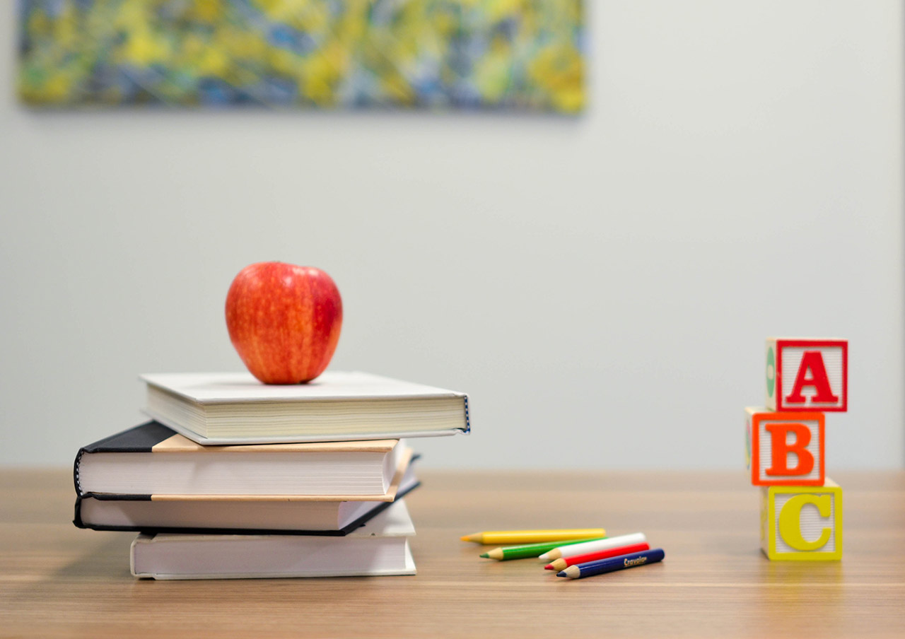 image of an apple on top of books